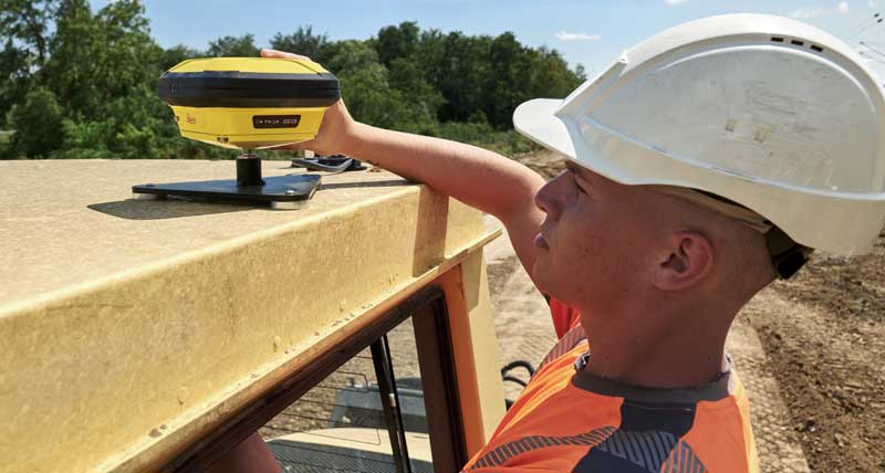 Un conducteur d’engin démonte l’antenne iCON gps 120 du toit d’un compacteur, rouleau compresseur. 